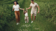 Joyful family enjoying a fun day outdoors in a green field, epitomizing togetherness and happiness.