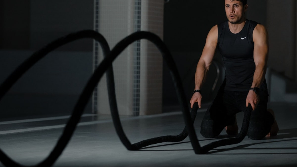 woman in black tank top and black pants sitting on black exercise equipment
